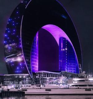 一栋建筑在夜晚被照亮成蓝色和紫色