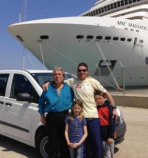 a family standing next to a white van in front of a cruise ship