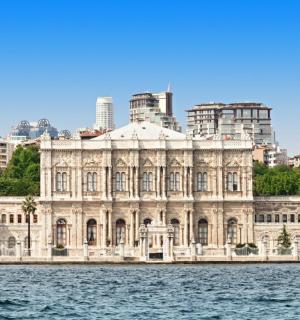 a building on the water in front of a city
