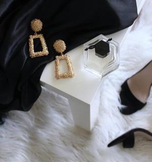 a woman in black dress with heels and a necklace