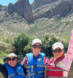 三个人站在河里，双臂高举