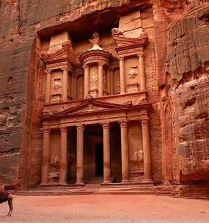 velbloud stojí před kamennou budovou