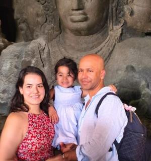 muž a žena držící dítě před sochou