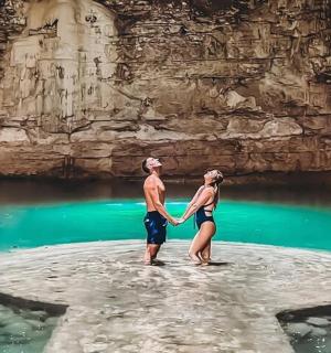 一名男子和一名女子站在水中的一块岩石上