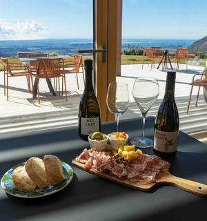 uma mesa com duas garrafas de vinho e um prato de comida