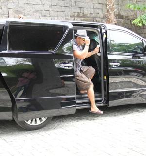 一名男子坐在一辆黑色货车的门口