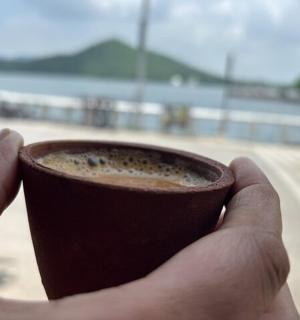 a person holding a cup of coffee in their hand