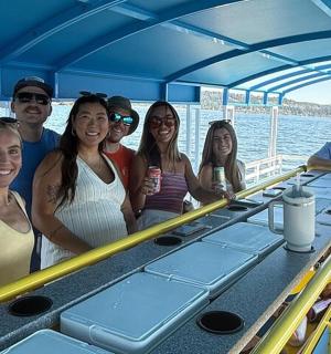 grupa ludzi pozująca do zdjęcia na łódce