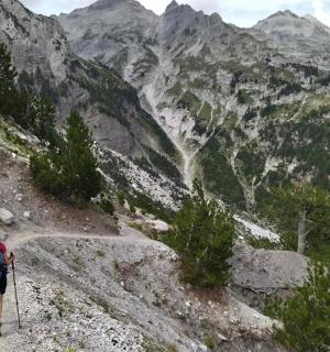 una persona con uno zaino che sale su una montagna