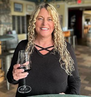 a woman is holding a glass of wine