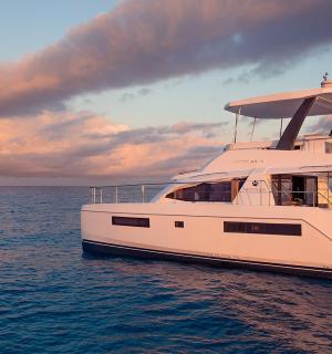 a white boat floating in the water under a cloudy sky