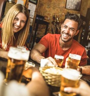 a group of people sitting at a bar drinking beer