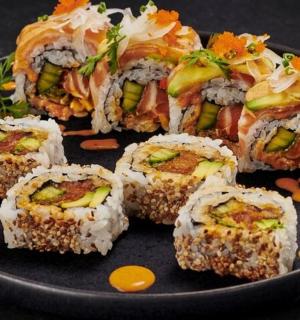 a black plate of sushi on a table