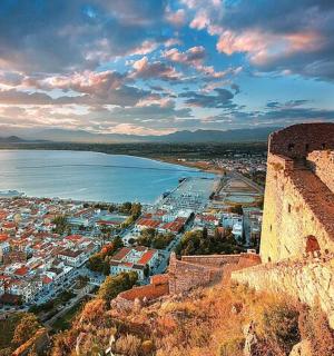 a view of a city with a castle and the ocean