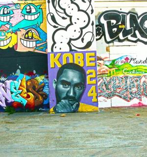 a wall covered in graffiti with a face painted on it