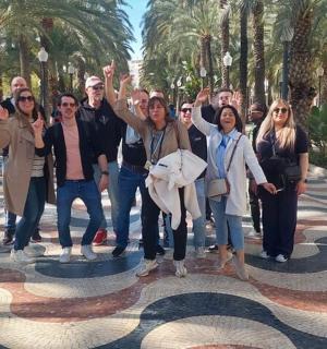 группа людей позируют для фотографии на тротуаре