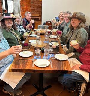 skupina lidí sedících kolem dřevěného stolu