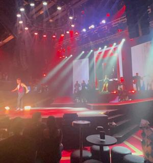 ein Mann, der vor einer Menschenmenge auf einer Bühne steht