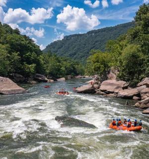 grupė žmonių plaustais upėje
