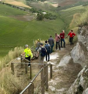a group of people walking down a path on a hill