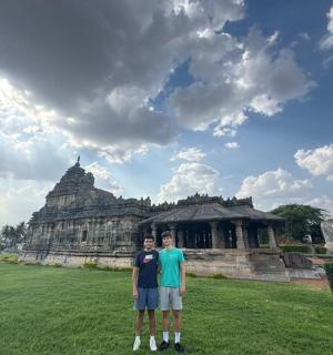 两名男子站在一栋建筑物前的田野里