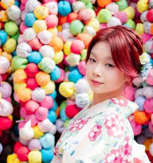 a woman standing in front of a wall of balls