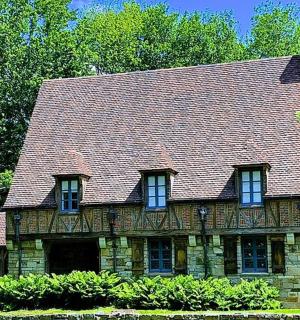 an old stone house with a brown roof