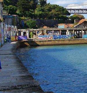 a woman standing on a sidewalk next to a body of water