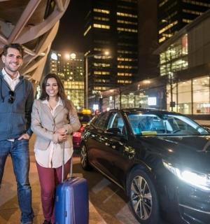 一男一女站在一辆带着行李箱的汽车旁边