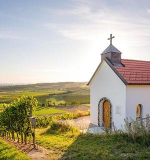 una petita capella blanca amb sostre vermell en un turó