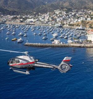 a helicopter flying over a body of water with boats