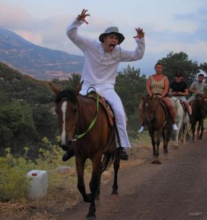 一群人骑着马沿着土路行驶