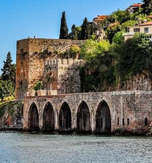 a stone bridge over the water in front of a mountain
