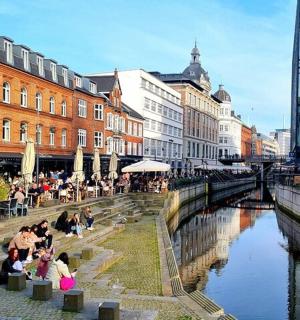 一群人坐在河边的桌子旁