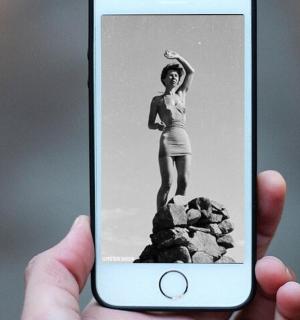 o persoană care ține în mână un telefon mobil cu o poză cu o fată