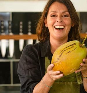 a woman is holding a large yellow fruit