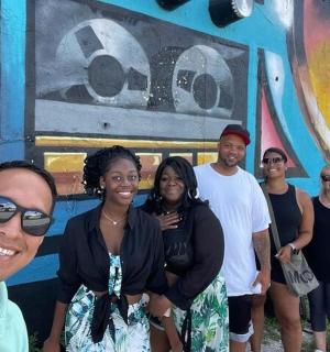 a group of people standing in front of a mural