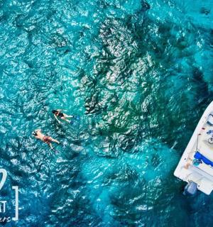 a group of people swimming in the water next to a boat