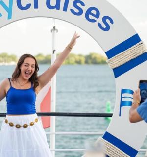 a woman standing on a boat with her arms in the air