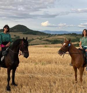 due donne a cavallo in un campo