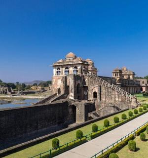 an old building with a garden and a river