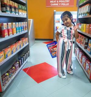 malé dítě stojí v uličce obchodu