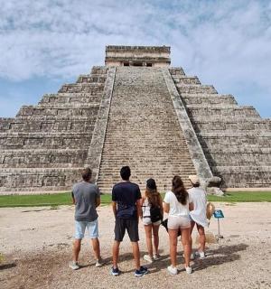 a group of people standing in front of a pyramid