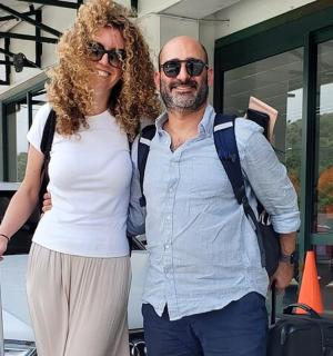 一名男子和一名女子站在一辆汽车前