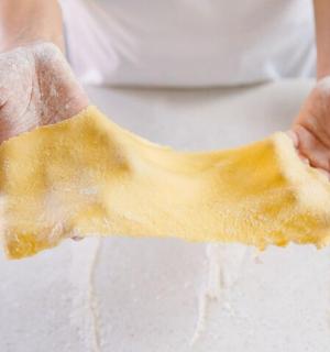 a person is holding a piece of dough