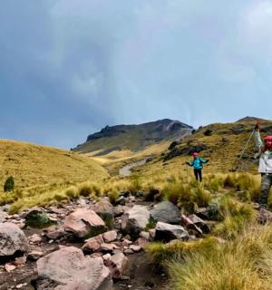 两个人走在山间的岩石小路上