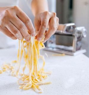 一个人拿着意大利面条在柜台上