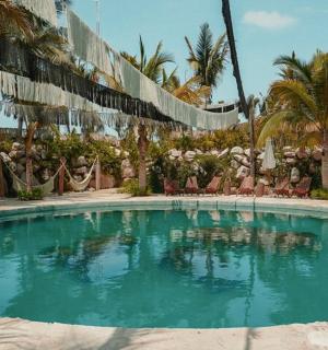 a large swimming pool in a resort with palm trees