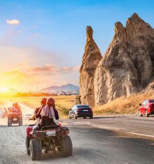 a group of people riding a quad bike on a road