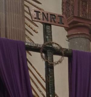 杆子上挂着紫色窗帘的十字架